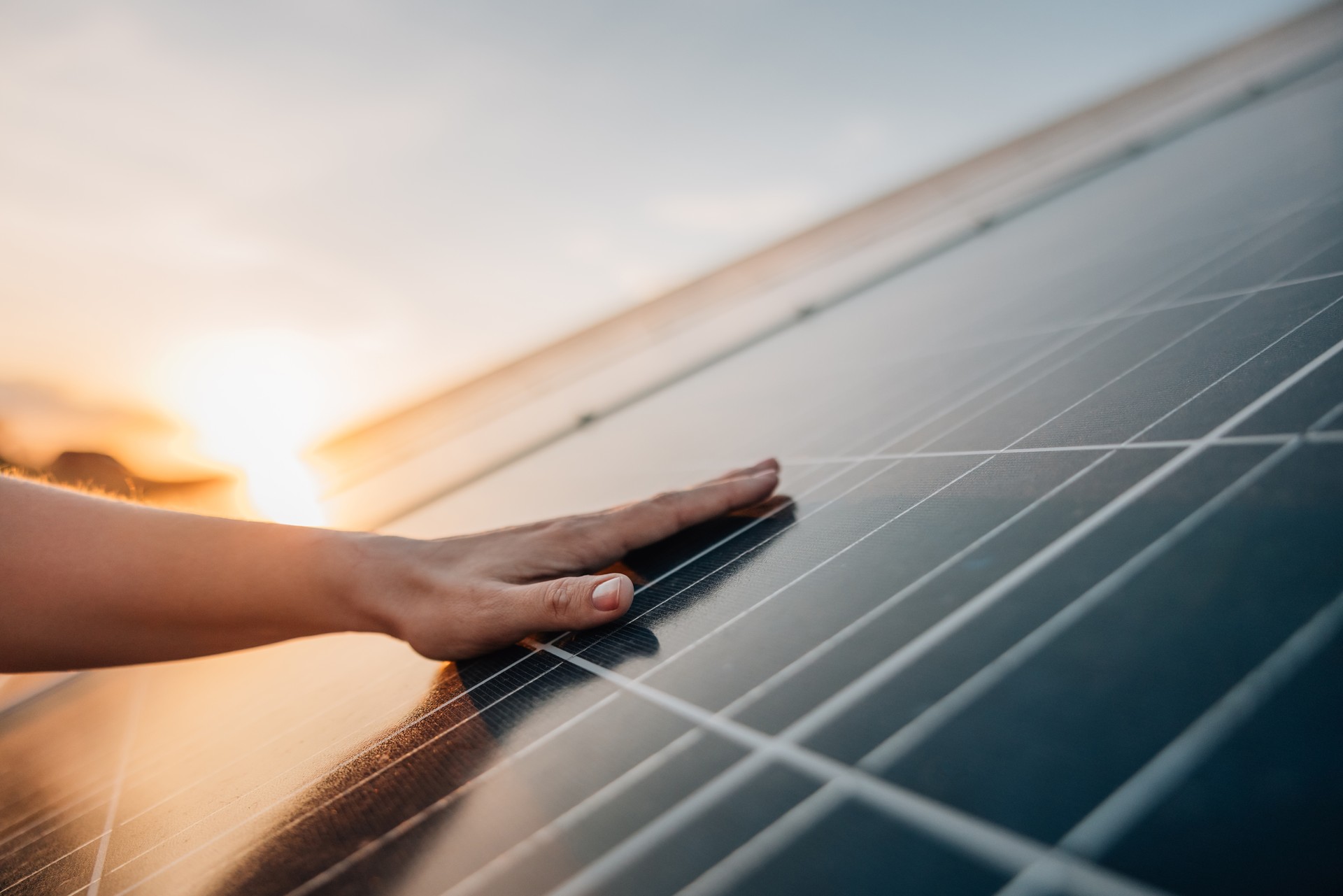 Human hand touching solar panel